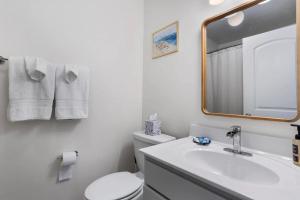 海泉市Pelican Cove Cottage located Downtown Ocean Springs的浴室里有洗手池、马桶和镜子。 更多25张照片