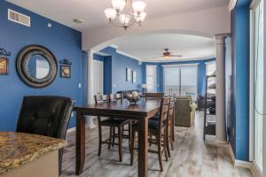 een eetkamer met blauwe muren en een tafel en stoelen bij Spacious Beachview End Unit in Legacy Tower 2 -809 - 3 bedroom 3 bath condo in De Buys