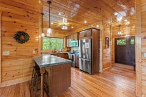 a kitchen with wooden walls and wooden floors and a refrigerator at Hot Tub & WiFi - Sky Pointe - LUX cabin in RRG KY in Rogers