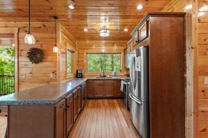 a kitchen with wooden cabinets and a refrigerator at Hot Tub & WiFi - Sky Pointe - LUX cabin in RRG KY in Rogers