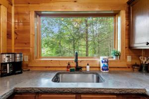 a kitchen with a sink and a window at Hot Tub & WiFi - Sky Pointe - LUX cabin in RRG KY in Rogers