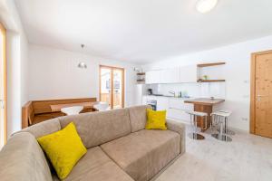 a living room with a couch and a kitchen at Olivia Home in Caprile