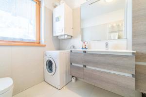 a bathroom with a washing machine and a sink at Olivia Home in Caprile