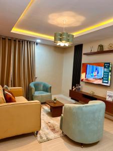un soggiorno con un divano e una TV di The Oluyole Luxe Escape a Ibadan