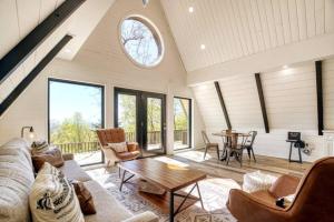 a living room with a couch and a table at The Black Aframe - HOT TUB and Mountain Views in Evergreen Farms