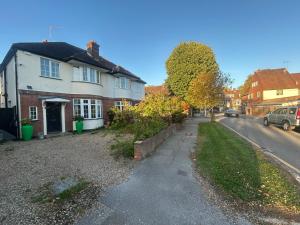 a street in a town with a white house at Eastcote 1st Floor Retreat 2 Bedroom Suite with Kitchen and Bathroom 2mins to Tube 20mins to Heathrow and Wembley 25mins Drive to Harry Potter World FREE PARKING in Eastcote