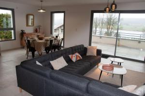 a living room with a blue couch and a table at Duplex 6 personnes, vue panoramique sur lac in Malbuisson