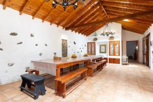 TanqueにあるCasa Rural El Naranjeroのダイニングルーム(大きな木製テーブル、ベンチ付)