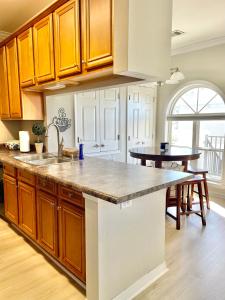 a kitchen with wooden cabinets and a counter top at 148 Beau Clair - Beachside Townhome with Pool in Long Beach in Long Beach