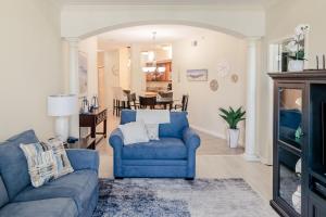 a living room with a blue chair and a couch at Beachview Condo at Legacy Tower 2 -206 - fully furnished 2 bedroom 2 bathroom in De Buys