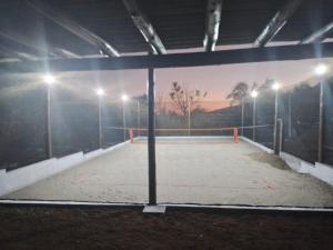 a tennis court in a building at night at Chalés Quintal da Serra in Lavrinhas