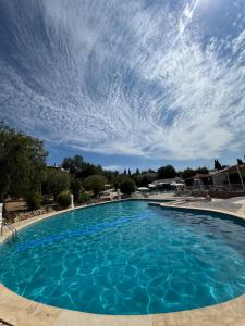 ein großer blauer Pool mit wolkigem Himmel in der Unterkunft Villa Valentina in Carvoeiro