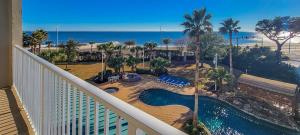 a balcony of a resort with a swimming pool and the beach at Beachview Condo at Beau View - 303 - fully furnished 3 bedroom 3 bathroom in De Buys