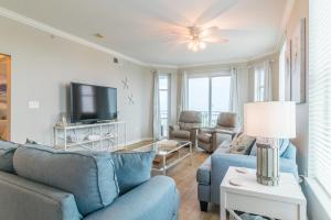 De BuysにあるSpacious Beachview End Unit in Legacy Tower 1-508 - 3 bedroom 3 bath condoの青いソファとテレビのあるリビングルーム