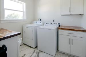 a white kitchen with two washes and a window at Brand New Home with Beach Views! Fully furnished 3 bedroom home in Gulfport in Gulfport +19 photos