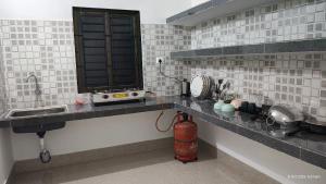 a kitchen with a sink and a fire hydrant on a counter at Dhriti Homestay in Guwahati