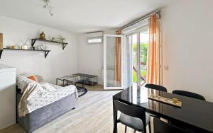 a living room with a table and a dining room at Cocon avec petit jardin centre Bondy in Bondy