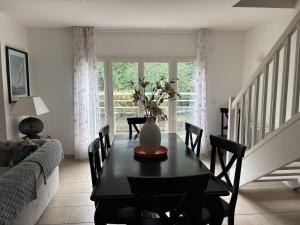 a dining room with a table and a vase with flowers on it at Superbe appartement en hyper centre, proche plage in Arcachon
