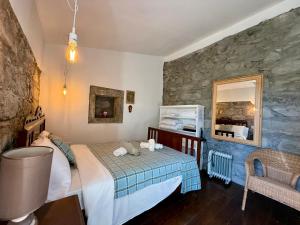 a bedroom with a bed and a stone wall at Haven Azores in Faial da Terra