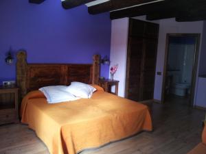 a bedroom with a bed with orange sheets and white pillows at Casa Rafeleta Hotel in Plan