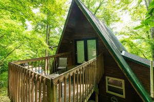 een hut in het bos met een groot terras bij Hot Tub - Haven at the Red - Red River Gorge KY in Slade +29 foto's