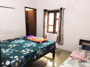 a bedroom with a bed and a window at Hegde Farmstay in Udupi