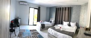 カイロにあるGarden city hotel Nile houseのベッド2台とテーブルとソファのある寝室