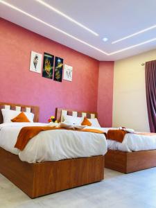 カイロにあるGarden city hotel Nile houseの赤い壁のベッドルームにベッド2台が備わります。