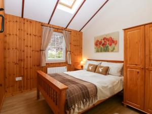 a bedroom with a large bed and a window at The Log Cabin in Gloucester