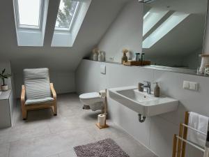 a bathroom with a sink and a toilet and a mirror at MaMa-Apartments - Netflix, Balkon, Kaffee & Tee, WIFI, Waschmaschine, familienfreundlich, kostenloser Parkplatz - 125 qm in Fulda +27 photos