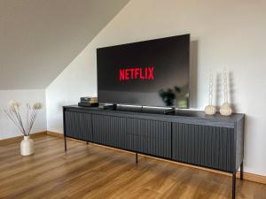 a flat screen tv on a wall in a living room at MaMa-Apartments - Netflix, Balkon, Kaffee & Tee, WIFI, Waschmaschine, familienfreundlich, kostenloser Parkplatz - 125 qm in Fulda