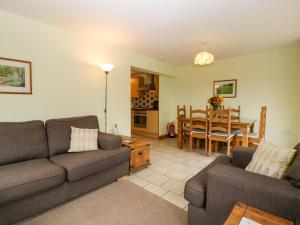 a living room with two couches and a dining room at Dovecote Cottage in Gloucester