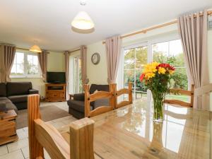 een woonkamer met een vaas met bloemen op een tafel bij Orchard Cottage in Hartpury