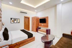 a bedroom with a bed and a tv and a couch at HOTEL O THE ELEGANT in Anūpnagar
