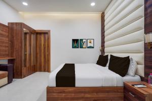 a bedroom with a bed with a wooden headboard at HOTEL O THE ELEGANT in Anūpnagar