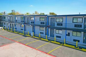 eine Reihe von Apartmenthäusern auf einem Parkplatz in der Unterkunft Super 7 Inn By OYO San Antonio NW Medical Center in San Antonio