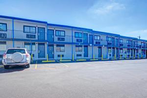 ein Auto, das auf einem Parkplatz vor einem Gebäude geparkt ist in der Unterkunft Super 7 Inn By OYO San Antonio NW Medical Center in San Antonio