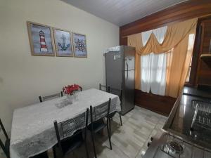 瓜拉图巴Casa Colonial em Guaratuba, próximo a praia的厨房配有白色的桌子和冰箱。