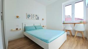 a white bedroom with a bed and two windows at Domo Ulleri in Olbia