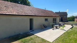 a patio with a table and chairs next to a house at Maison de charme 3 chambres in Saligny-sur-Roudon