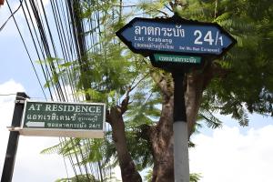 a street sign on a pole with some street signs at Minimalist Oasis - Monthly Stay Near Airport, Local Gems & Mall - Minimum Stay 28 Days in Bangkok