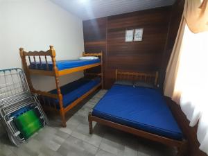 瓜拉图巴Casa Colonial em Guaratuba, próximo a praia的一间卧室配有两张双层床,铺有蓝色床单。