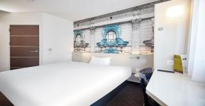 a bedroom with a white bed and a building at B&B Hotel Łódź Centrum in Łódź