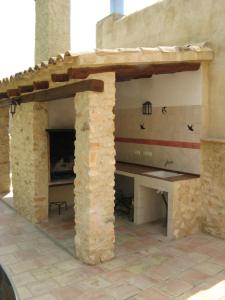 アルアマ・デ・ムルシアにあるAlojamientos Rurales Cortijo Las Golondrinasの石壁の屋外キッチン(テーブル付)