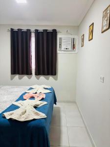 een slaapkamer met een bed met een blauwe deken en een raam bij Apartamento Paraíso Refúgio - Manoah Beach Flats in Maragogi