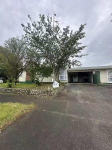 a house with a tree in front of a driveway at 3 bedrooms House,77 Slacks Rd in Palmerston North