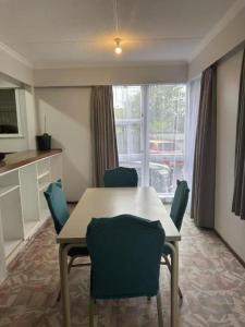a dining room with a table and chairs and a window at 3 bedrooms House,77 Slacks Rd in Palmerston North