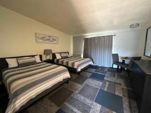 Una cama o camas en una habitación de Ponderosa Gardens Motel 35 fotos más