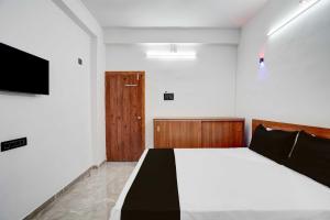 - une chambre avec un lit et une porte en bois dans l'établissement Hotel O DSP Lodge And Restaurant, à Jadhavwadi