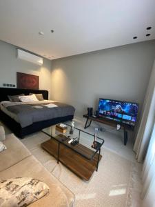 ein Schlafzimmer mit einem Bett und einem Flachbildfernseher in der Unterkunft Alsultan Cozy Studio in Khobar
